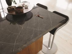 a black marble counter top with two bowls and spoons sitting on the table next to it