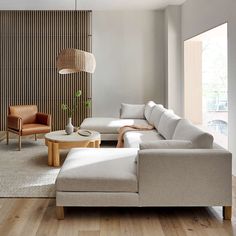 a living room filled with furniture next to a window and wooden floored walls in front of a large window