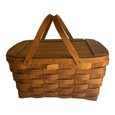 a large wooden basket with handles on the top and bottom, sitting against a white background