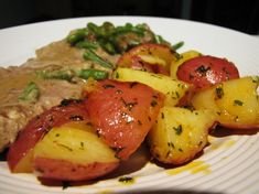 a white plate topped with potatoes and meat