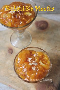 two glasses filled with food on top of a wooden table