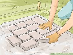 a person laying bricks on the ground with their hands over them to make it look like they