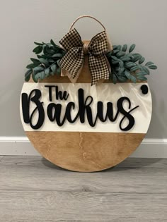 a wooden sign that says the backus hanging on a wall next to a door