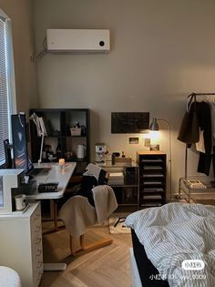 a bedroom with a bed, desk and computer on the wall next to a window