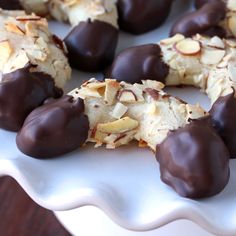 chocolate covered almonds are arranged on a white plate