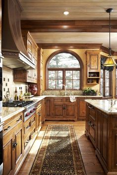 a large kitchen with wooden cabinets and an island in front of the stove top oven