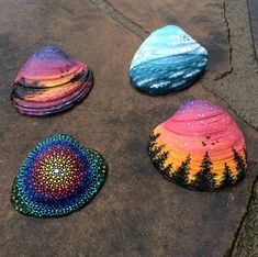 three painted rocks sitting on top of a sidewalk