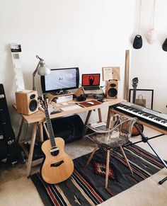 a desk with a keyboard, guitar and other musical instruments