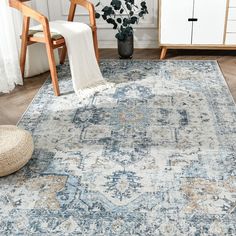 an area rug with blue and white colors in a living room next to a chair