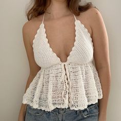 a woman wearing a white crochet halter top