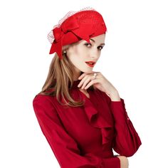 a woman wearing a red hat with a big bow on it's head is posing for the camera