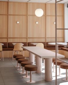 an empty room with several chairs and tables in it, along with wooden paneling