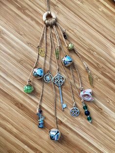 an assortment of charms hanging from a string on a wooden floor with the caption easy com