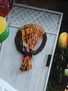 a bunch of balloons are on the ground near a door with a wreath and some candy canes