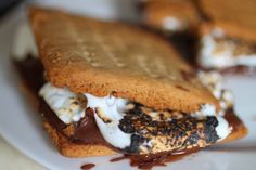 a close up of a sandwich on a plate with melted chocolate and marshmallows