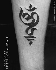 a black and white photo of a person's leg with an arabic tattoo on it