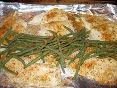 fish and green beans are on foil in the oven, ready to be cooked for dinner