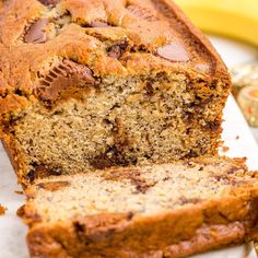 a loaf of banana nut bread on a plate with two slices cut off the side