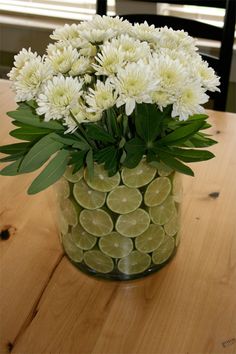 a vase filled with white flowers on top of a wooden table