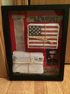 an american flag and some letters in a shadow box with rope attached to the frame