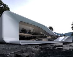 an unusual white building sitting on top of a rocky hillside