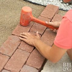 a man is laying bricks on the ground