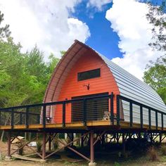 an orange building with a metal roof in the woods