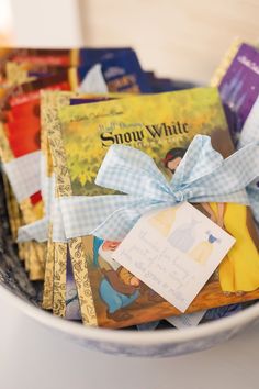 a bowl filled with lots of books on top of a white countertop next to a blue ribbon