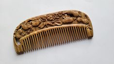 The classic design and shape of this comb is perfect for people who appreciate the beauty of vintage style combs.  The traditional arrangement of peanuts and Persimmon  is hand-carved wooden comb on both sides.  Peanuts and persimmons means holidays and celebration throughout Asia.  This pattern carries the meaning of good luck, happiness, longevity and abundance. They are important symbols for people to express blessings and prayers.  In Chinese folk culture, peanut and persimmon combination often also send the wishes of good things will happen and a happy and long lasting marriage.   Handmade from Green Sandalwood, this wooden comb will provide gentle and non-scratch treatment of the hair and scalp.  This hardwood comb can massage your scalp to stimulate and release natural oils througho Wood Comb Design, Chinese Hair Comb, Wooden Wide Tooth Comb, Chinese Wooden Hair Comb, Folk Culture, Good Meaning, Wooden Comb, Styling Brush, Idea Gift