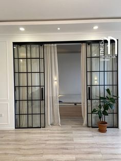 an empty room with glass doors and a potted plant