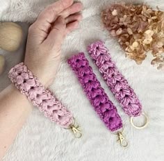 two crocheted key fobs are shown on a white blanket next to some rocks