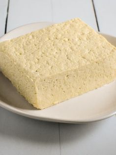 a square piece of cake sitting on top of a white plate