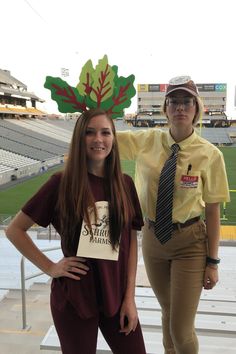 two people standing next to each other in front of a stadium