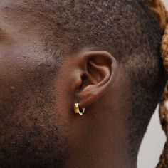 a man with dreadlocks wearing an earring