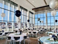 a room filled with lots of tables covered in balloons