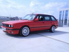 a red car parked in front of a tall building