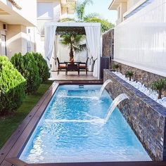 an outdoor swimming pool surrounded by greenery