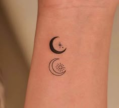 a woman's arm with a tattoo on it that has two crescents and the sun