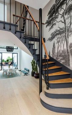 a staircase leading up to a living room with a painting on the wall behind it