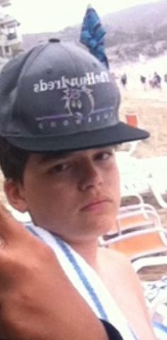 a young man wearing a hat at the beach