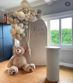 a teddy bear with balloons attached to it