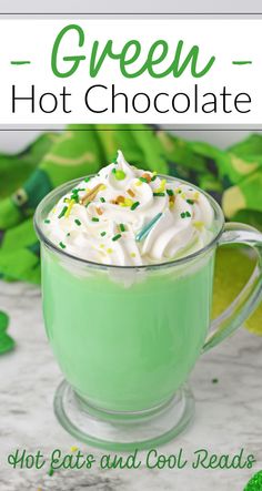 green hot chocolate in a glass mug with whipped cream and sprinkles on top