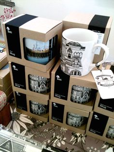 a stack of coffee mugs sitting next to each other on top of cardboard boxes