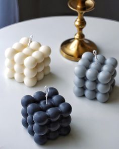 three small pieces of fruit sitting on top of a white table next to a candle