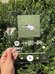 someone is holding up a clear acrylic sign with an image of a man laying on the ground