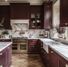 a kitchen filled with lots of purple cabinets and white counter tops next to a stove top oven