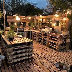 an outdoor patio with wooden pallets and lights