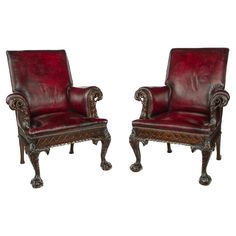 a pair of red leather chairs sitting next to each other