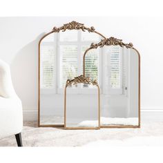 a mirror sitting on top of a white rug in front of a chair and window