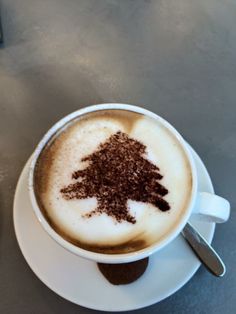 a cappuccino with chocolate sprinkles in it on a saucer